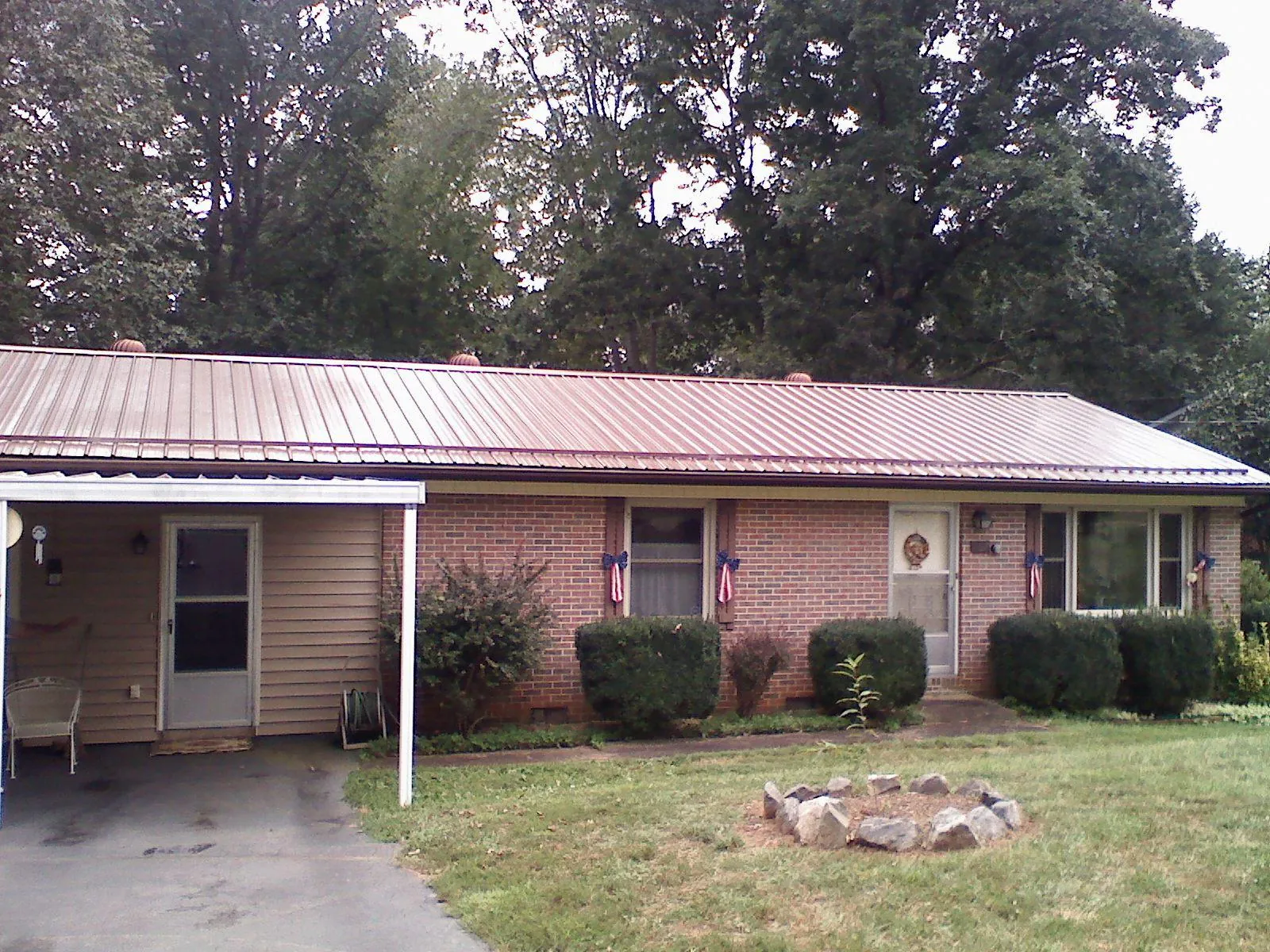 Bronze metal roof and carport on a brick ranch home — Roof Repair work by our crew in Left Hand